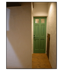 白い漆喰の壁とパステルグリーンのドア